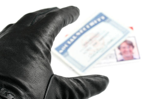 Identity theft depicted by a gloved hand reaching for personal ID, representing stolen identity risks.