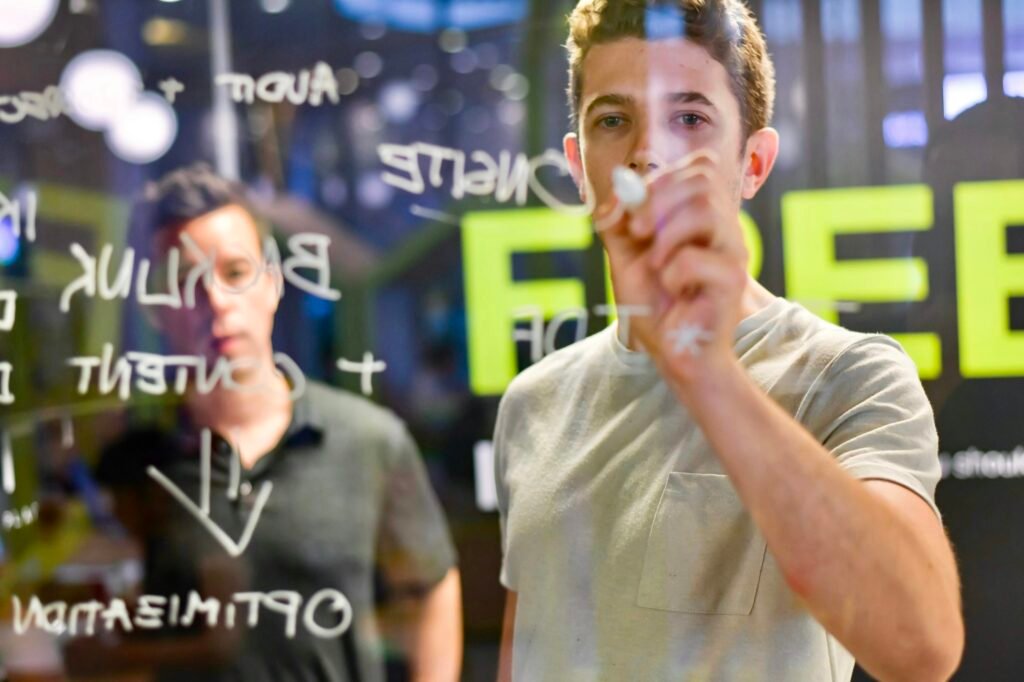 A digital marketing professional writes strategy notes on a glass board while reviewing online visibility, symbolizing structured online reputation repair.